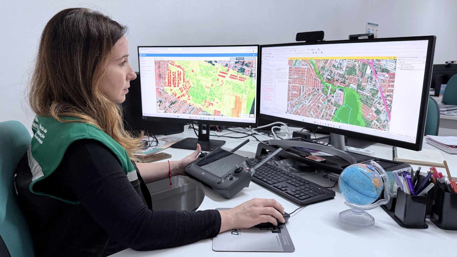 Fiscal avalia imagens de mapas em frente a computador
