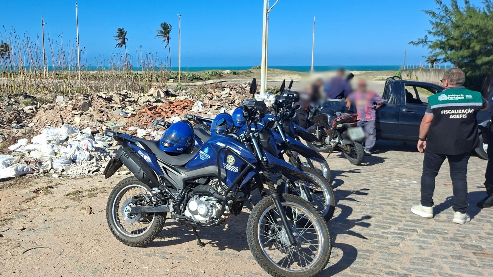 Fiscais da Agefis realizam autuação de proprietário de veículo; ao lado, resíduos de obras e motos da GMF