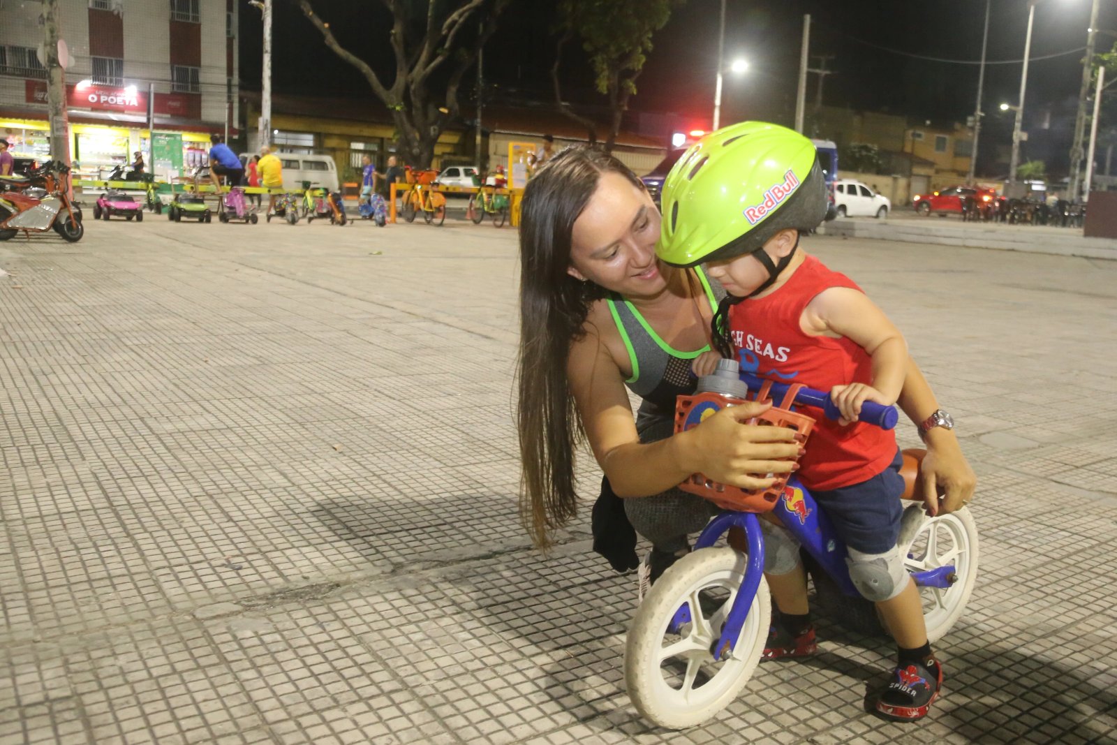 A maquiadora Vitória Régia Ferreira abraça o filho Ramon, de dois anos, que está em uma bicicleta sem pedal